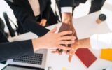 Multiracial business people staking hand together