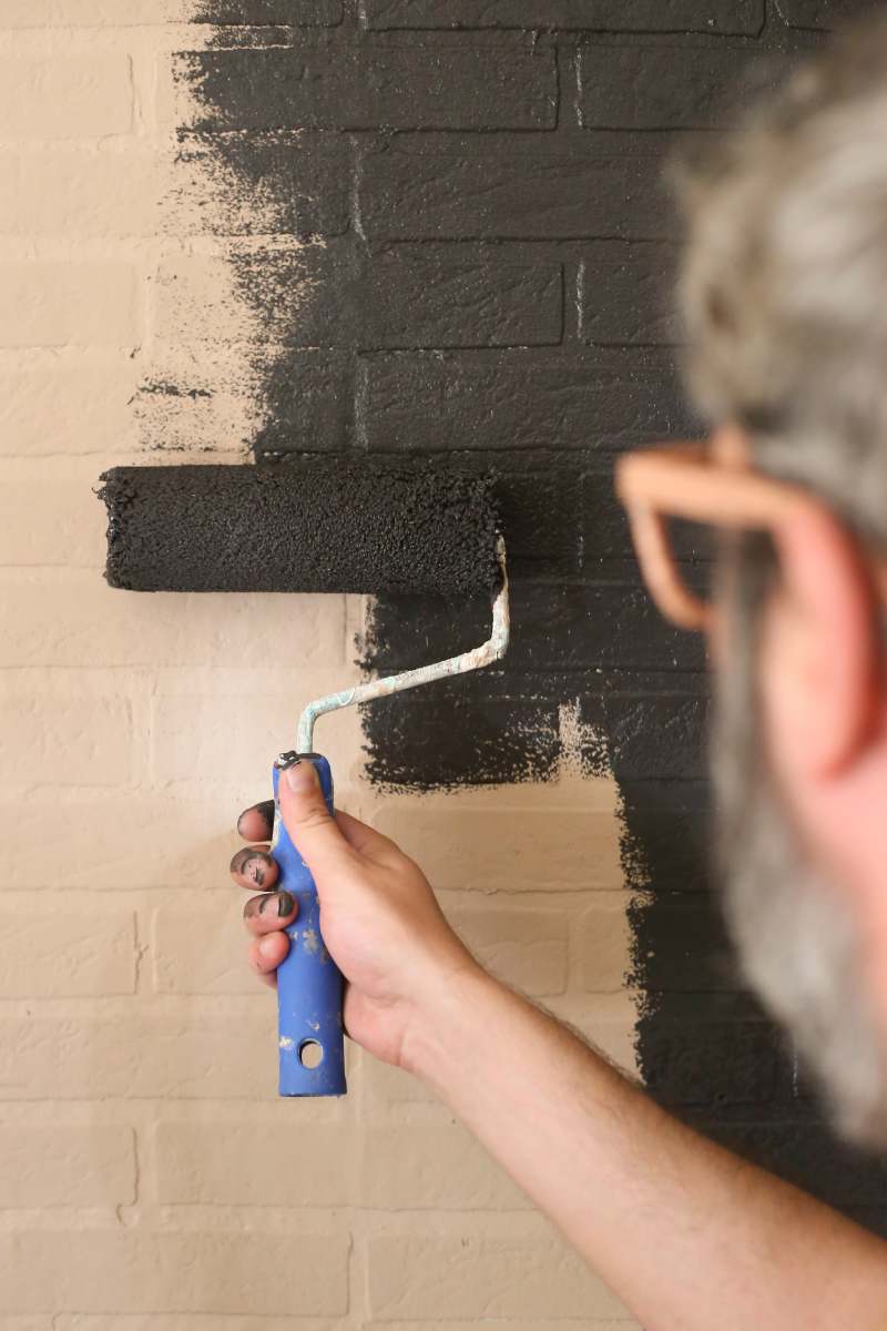 Man painting the wall black