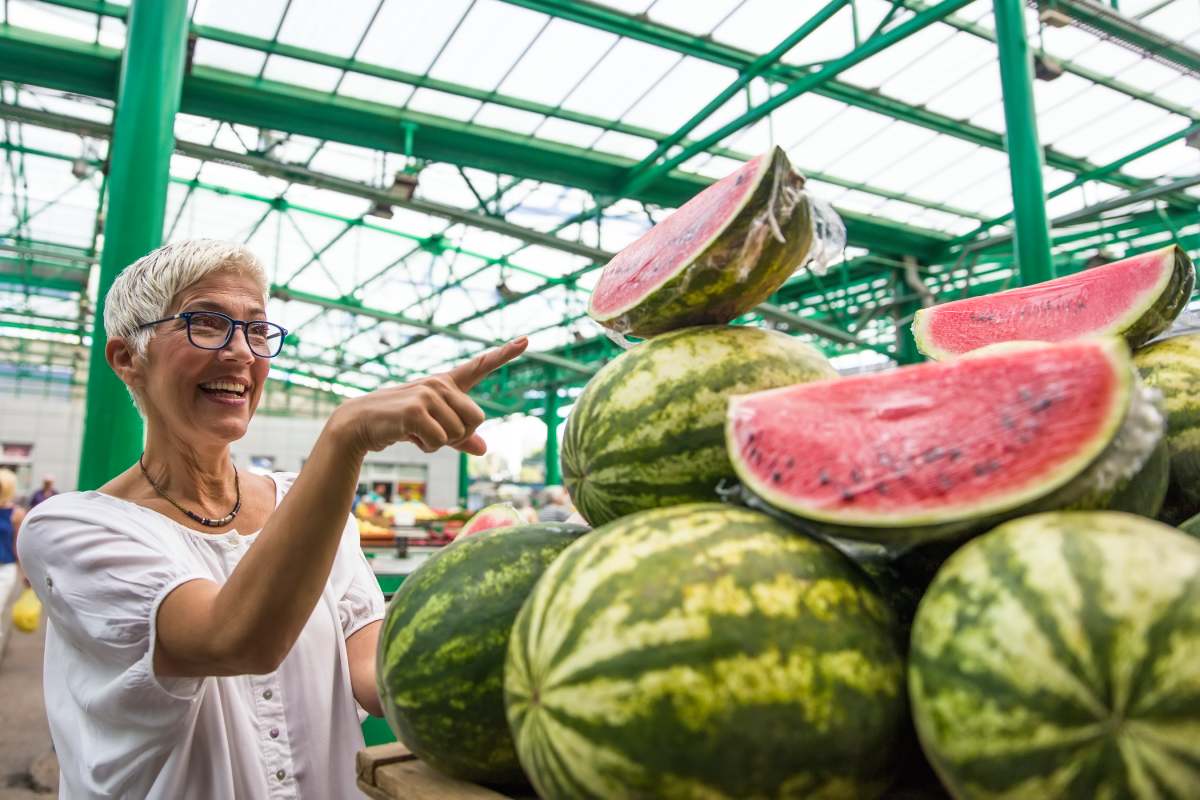 Portrait of senior woman buying watermelon on market